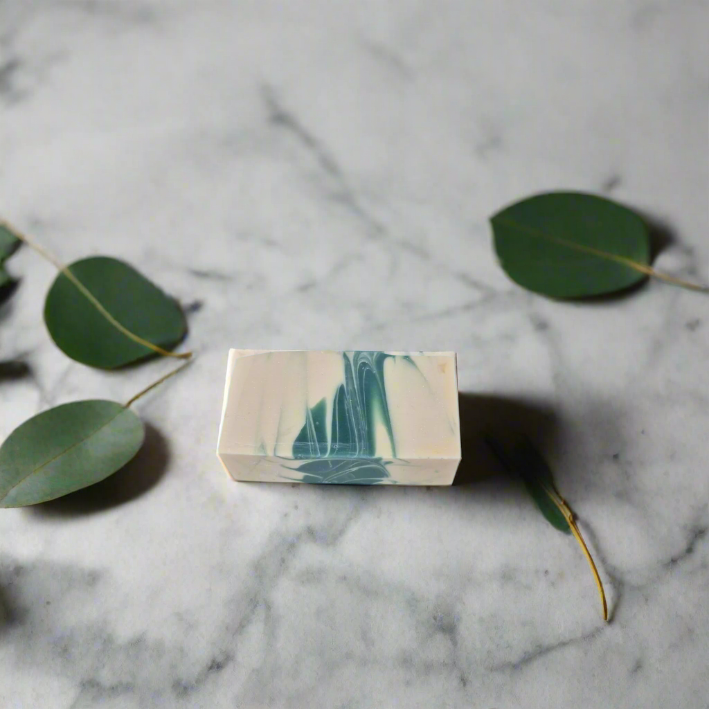 Marble-patterned soap bar on a marble surface with green leaves
