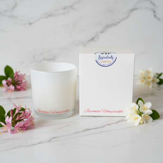 White candle in a glass container with a white box labeled 'VIP Essentials' on a white background
