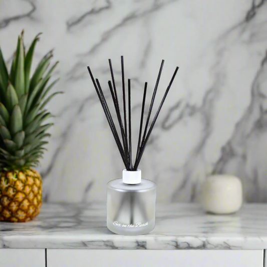 Silver diffuser with black sticks on a white background