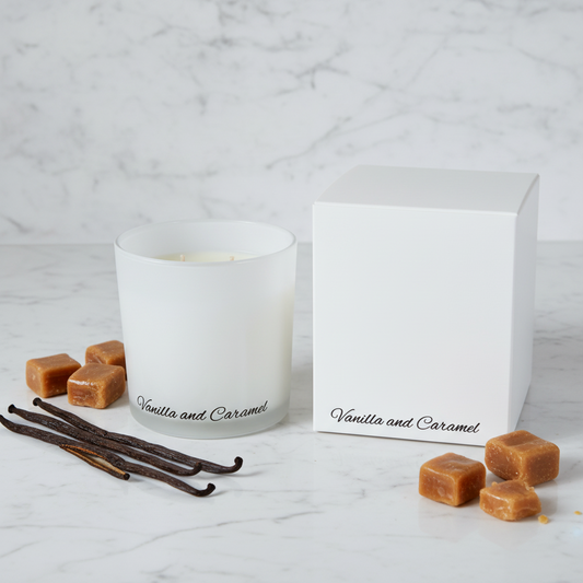 White candle with 'Vanilla and Caramel' text next to its white box on a blue background