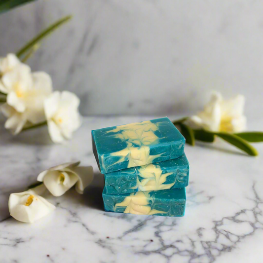 Stack of green and white soap bars on a blue background