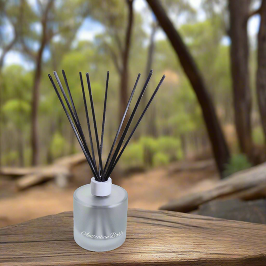 Fragrance diffuser with sticks on a wooden surface in a forest setting