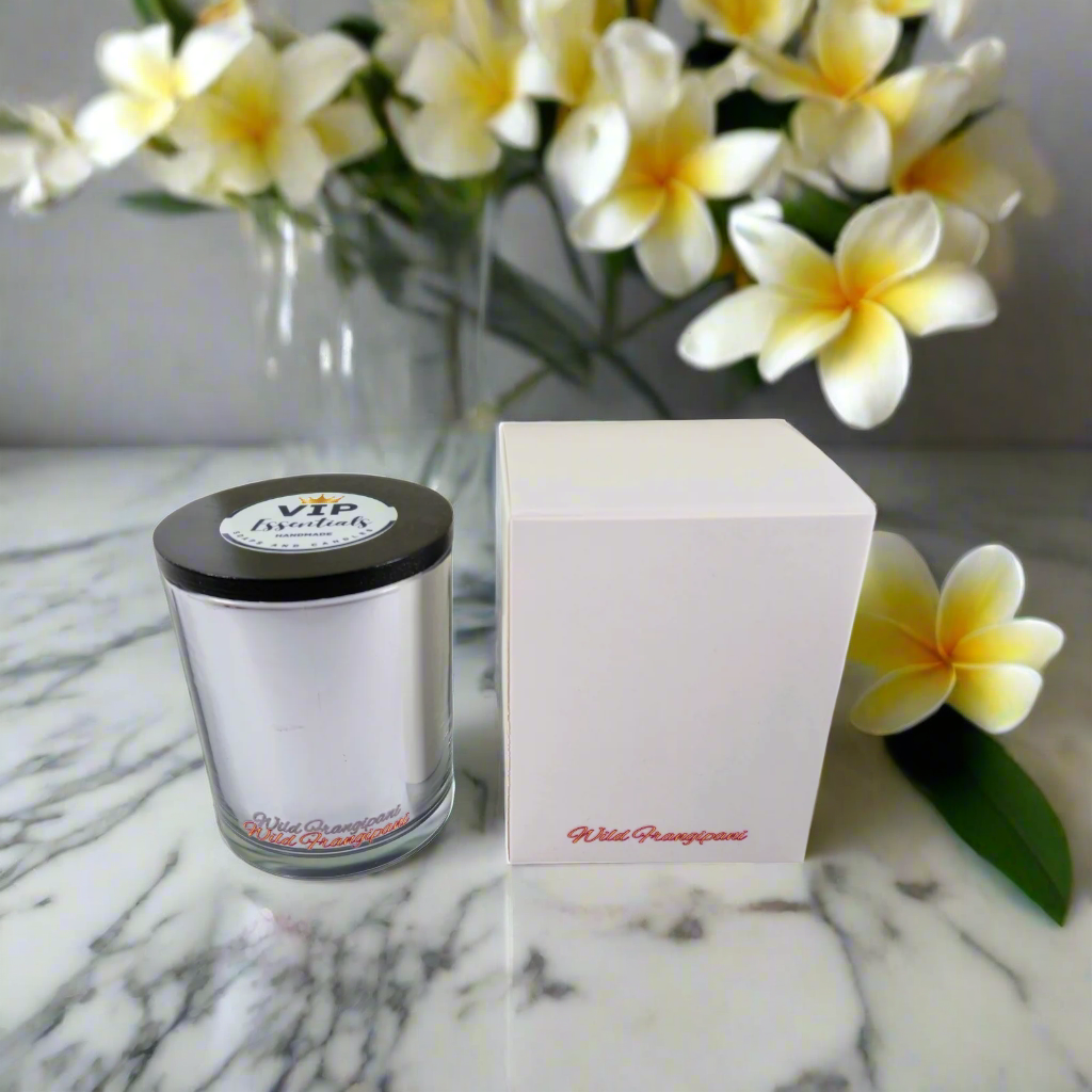 Clear glass candle with black lid and white box on a white background
