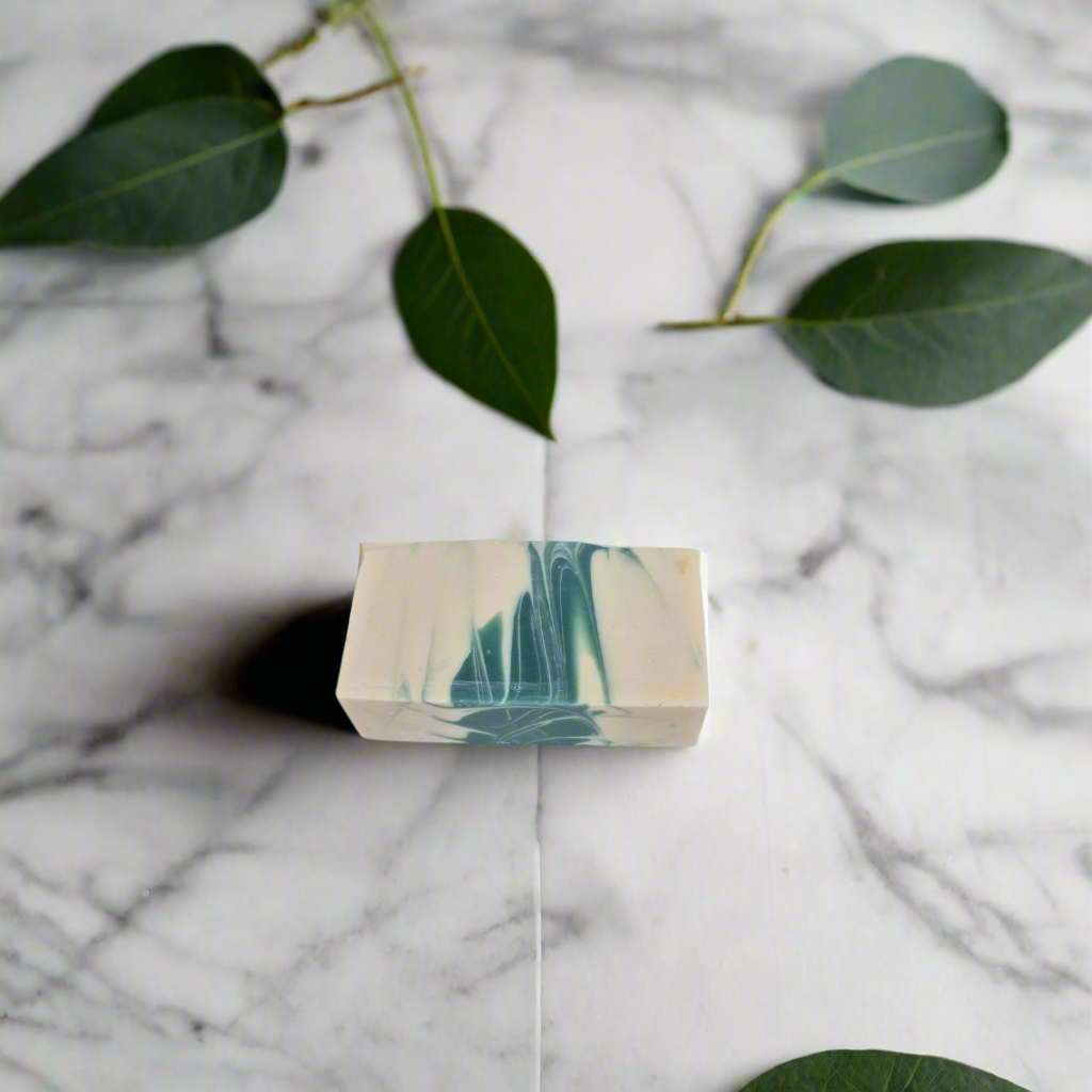 Marble-patterned soap bar on a marble surface with green leaves