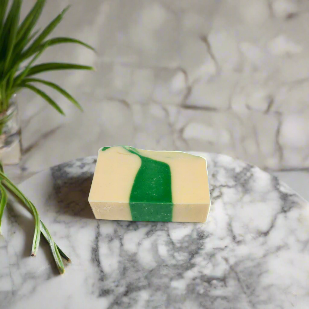 Bar of soap with green and beige stripes on a marble surface with a plant in the background