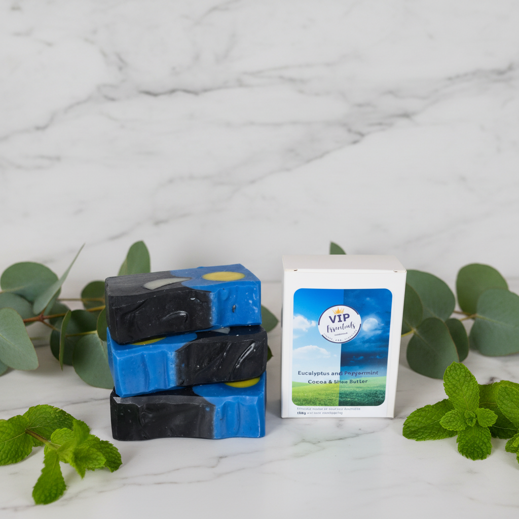 Three bars of black and blue soap with a box labeled 'VIP' on a marble surface with green leaves.
