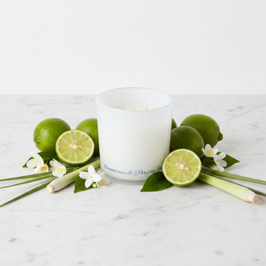 White candle in a glass container on a blue background