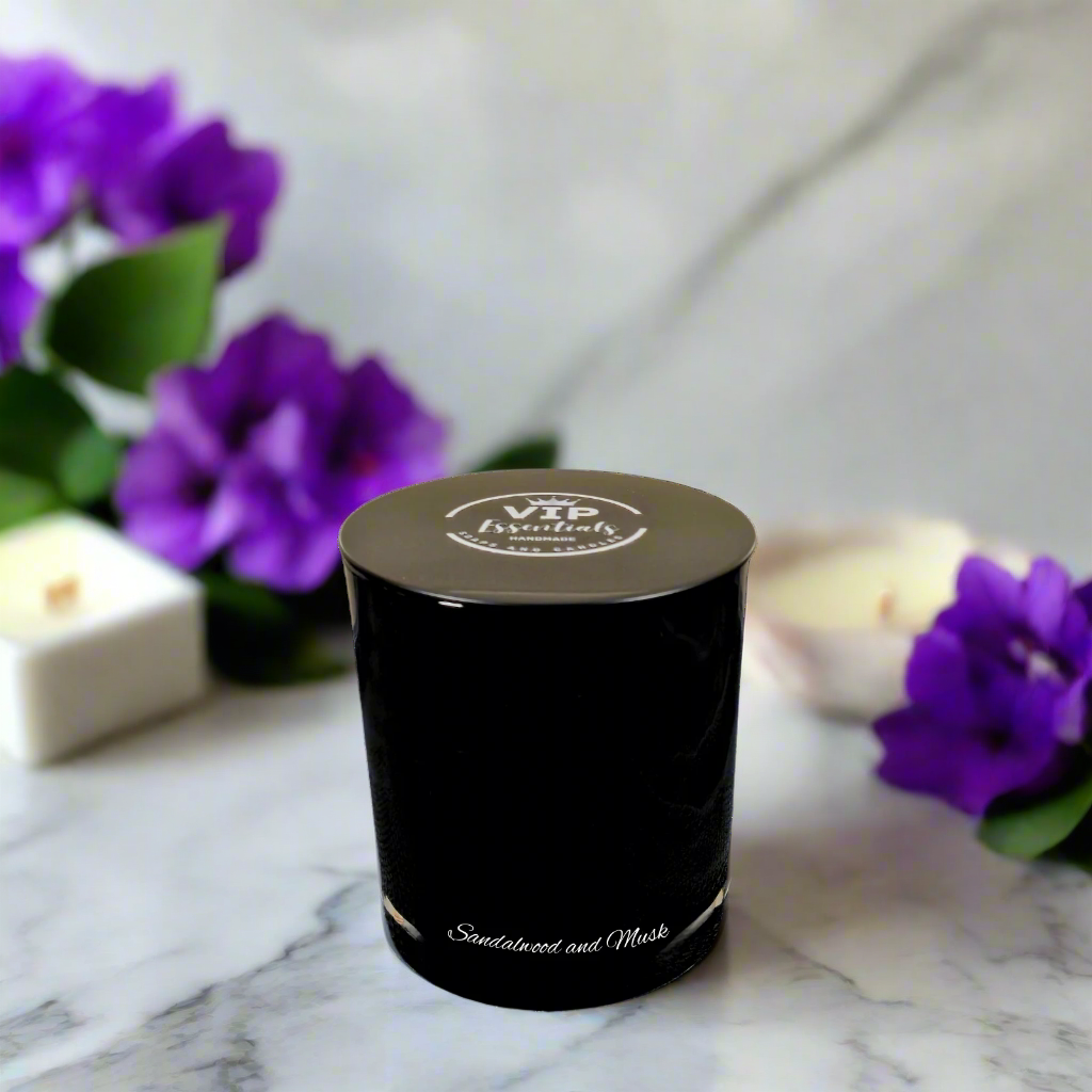 Black candle in a decorative container with 'VIP Essentials' branding on a white background