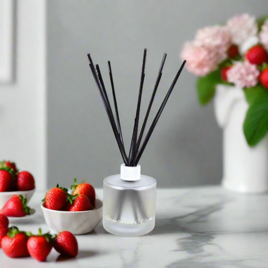 Silver diffuser bottle with black sticks on a white background