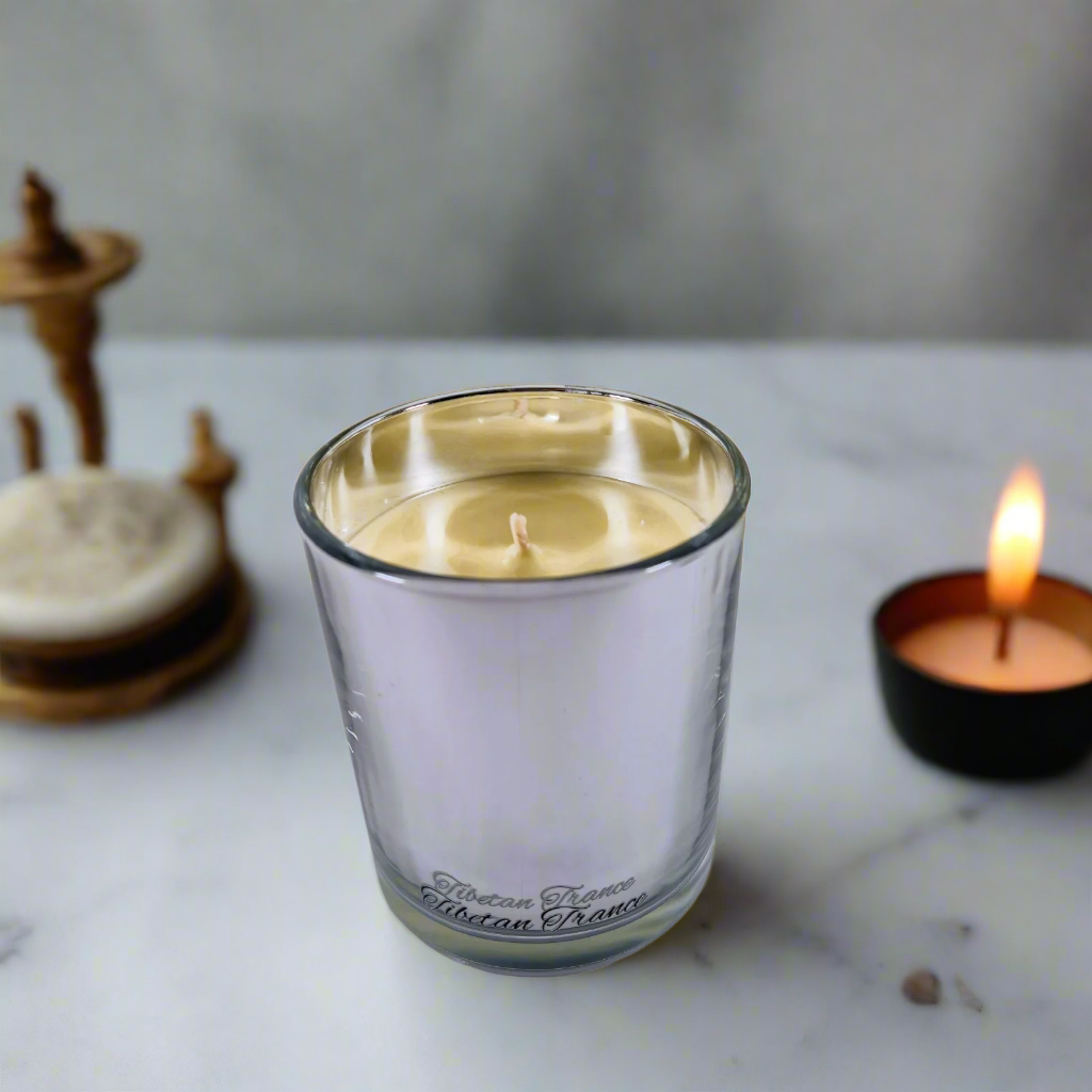 Clear glass candle with a visible brand name on a white background