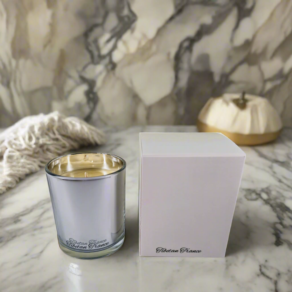 Silver candle holder and white box on a marble surface with floral background